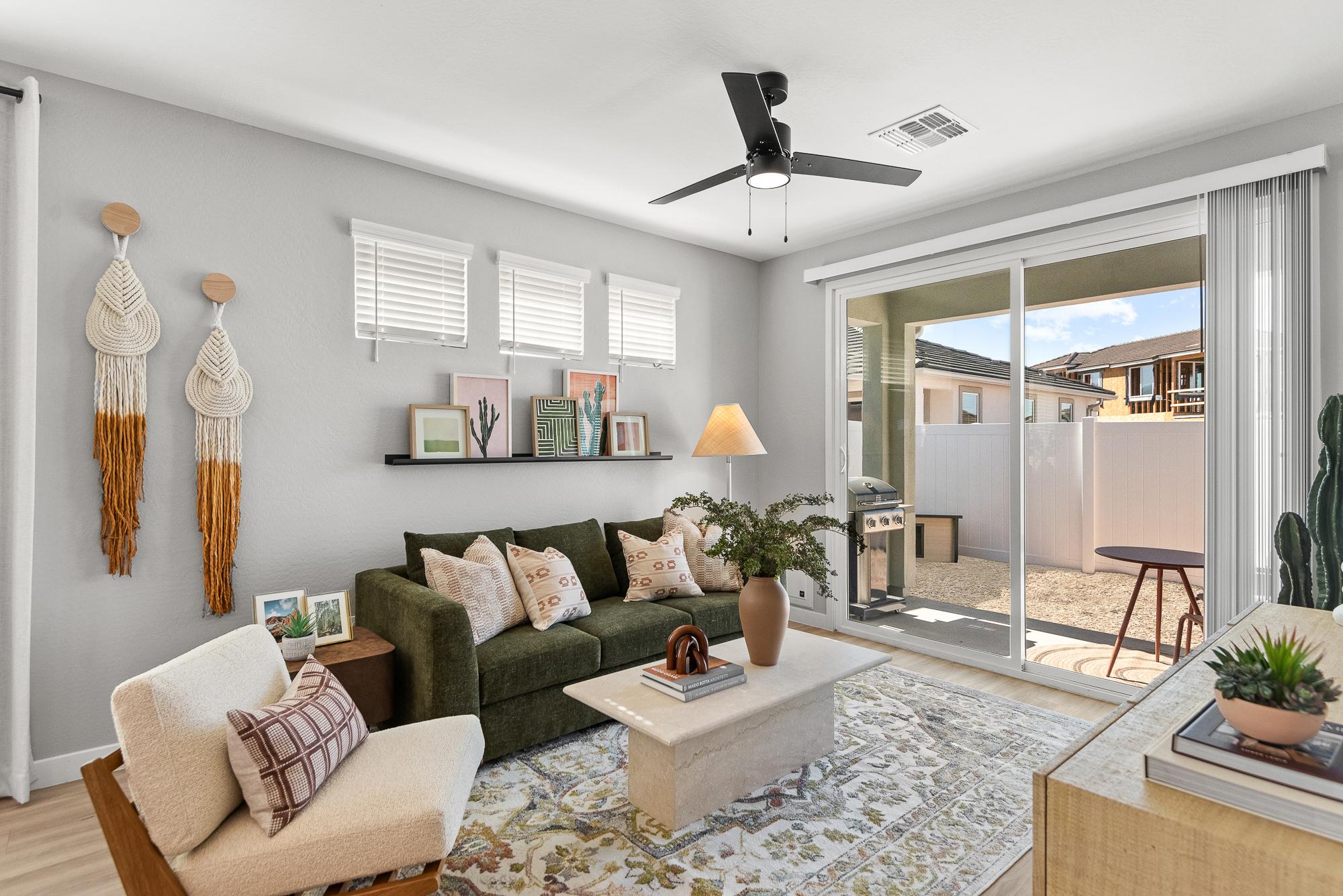 Origin modern living room with green sofa, wall art, large rug, and sliding glass doors opening to a sunny patio.